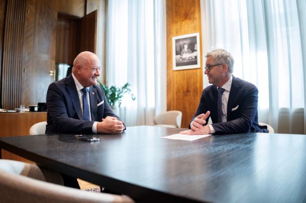 Bundeskanzler Christian Stocker und der EU-Kommissar für Inneres und Migration Magnus Brunner unterhalten sich an einem Tisch